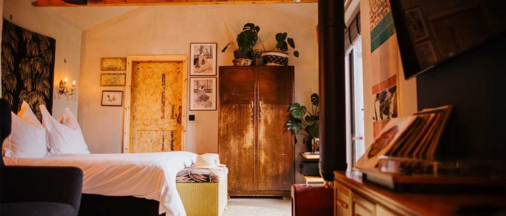 Luxurious bedroom with large double bed and a record player at luxury B&B Bethnal and Bec