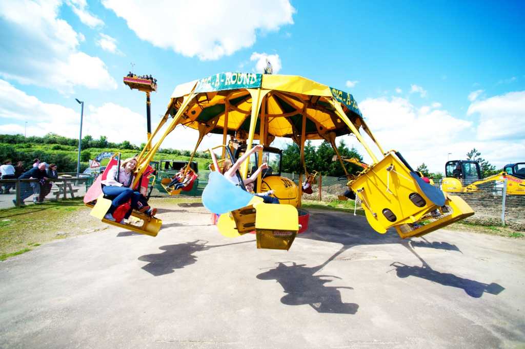 People sitting on a ride at Diggerland that spins them round in a circle